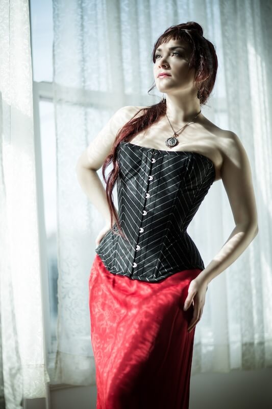 What do I wear under a corset? When I wear a tank top, it slides up under  the corset. If I wear panties over the tank and then the corset, it's hard